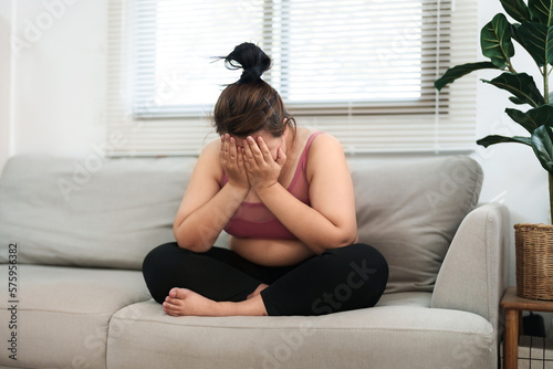overweight woman sitting on the sofa stress about loss weight..