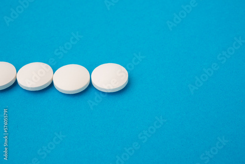 White round pills on blue textured background