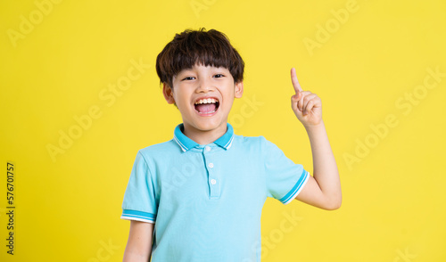portrait of an asian boy posing on a yellow background