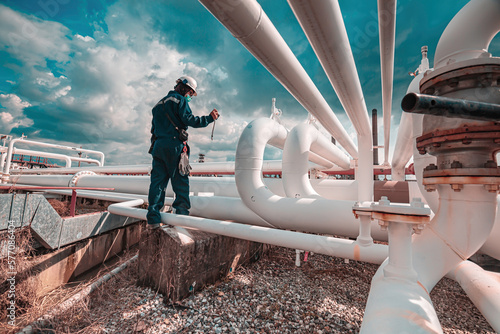 Male worker inspection at steel long pipes and pipe elbow in station oil factory during refinery valve of visual check record pipeline tank oil and gas