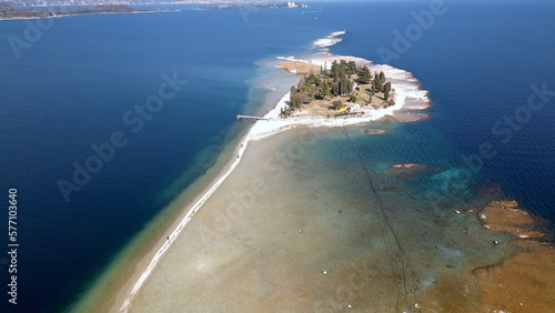 Italy, Lake Garda ,San Biagio Island , Rabbit Island - the shallow waters of the lake allow you to walk and reach the island on foot - water emergency in Lombardy , drought lowering of the water level
