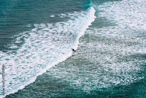 Aerial view of surfers surfing waves in Beach of Antuerta in Ajo, Trasmiera, Cantabria,