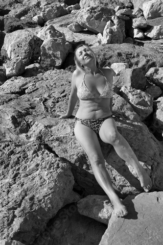 Dojrzała kobieta w bikini na kamienistej plaży