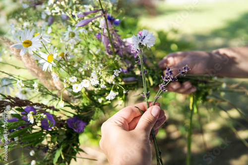 Making a Festive flower wreath, circlet of flowers, making coronet of flowers on a bright sunny afternoon. Preparing for Midsummer night fest. How to Make a Flower Crown. Festival flower crown.