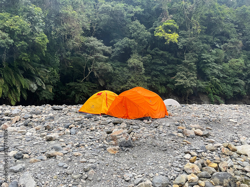 orange tent outdoor camping on river bed hot spring forest mountain 