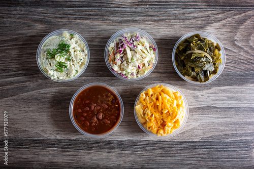 A top down view of several side dishes featuring macaroni and cheese, potato salad and coleslaw.