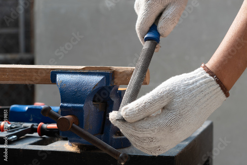 Male hobby retirement. Senior man is using rasp on wood for assembling hammer handle.