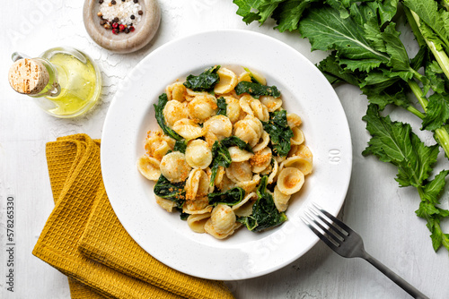 Top view of pasta recchiette con le cime di rapa e le acciughe popular in Southern Italy dish, typical of Apulia. Made with anchovy, bread crumbs and rapini, or broccoli rabe or turnip greens.