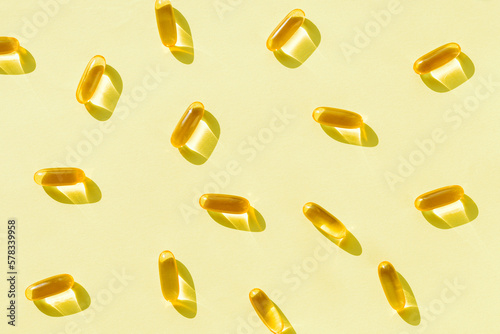 Pills of omega 3 close up on pastel green background with shadow. Health care concept. Supplements and vitamins. Top view. Flat lay. Selective focus