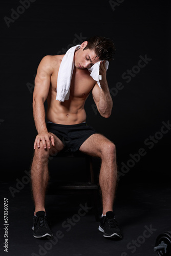 Get your sweat on. Studio shot of a muscular bare-chested young man isolated on black.