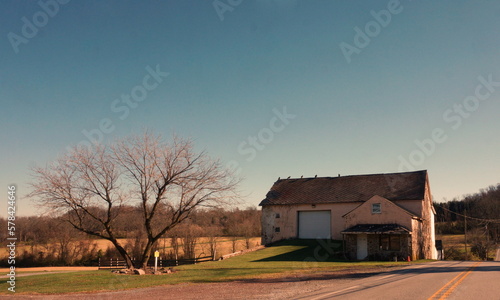 Old Barn with Birds Perched on Roof in Fall with Blue Sky