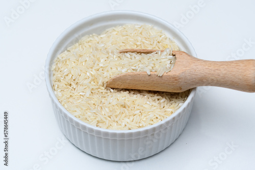 Ryż basmati w okrągłej miseczce z drewnianym nabierakiem