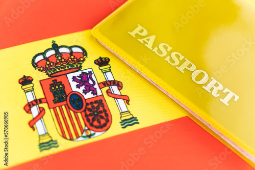 Flag of spain with passport. Travel visa and citizenship concept. residence permit in the country. a yellow document with the inscription passport is on flag. Close up, top view