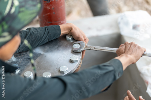 Workers hand holding machine tightening nut, The mechanic is repairing the machine in the factory, Maintenance man bolting torque in industrial plant