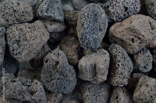 Porous black volcanic rock. Lava stone, pumice stone, or volcanic pumice with distinctive pores