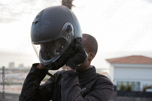 A motorcyclist puts on his helmet before setting off, road safety concept