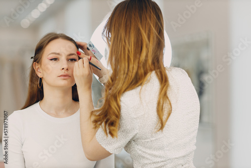 Beautiful young woman applying makeup beauty visage brush.