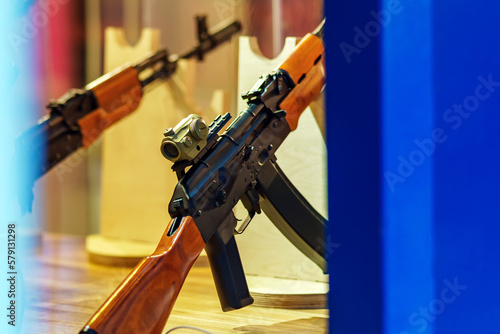 A model of a Kalashnikov assault rifle with a colimator sight stands in a shooting gallery