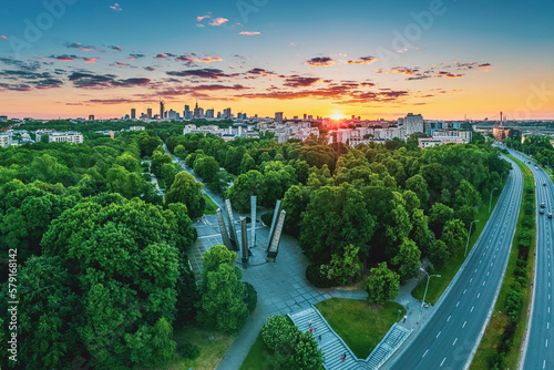 Sunset over green park and Warsaw city center, aerial landscape