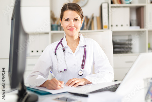 Portrait of polite experienced female doctor holding consultation in clinic office. Concept of modern medical services