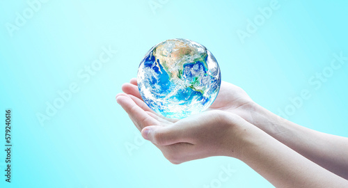 Hand holding blue planet earth globe with blurred background . Elements of this image furnished by NASA.