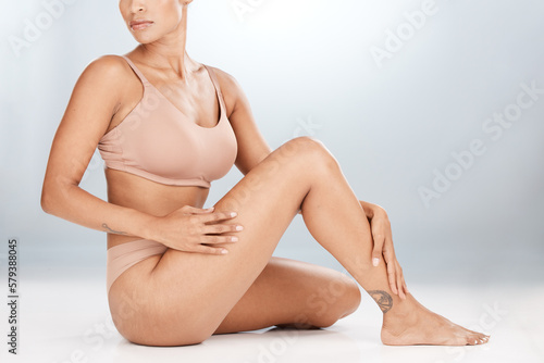 Legs, body and woman in underwear isolated on studio background for cellulite, stretch marks or natural skincare. Aesthetic, dermatology and beauty person with hair removal on floor in mockup space