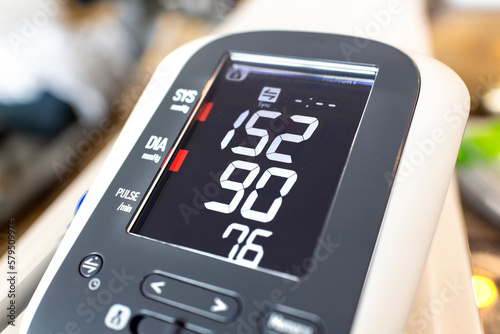 A home blood pressure monitor with high diastolic and systolic measurement numbers which may indicate stress or an unhealthy lifestyle or poor heart health.
