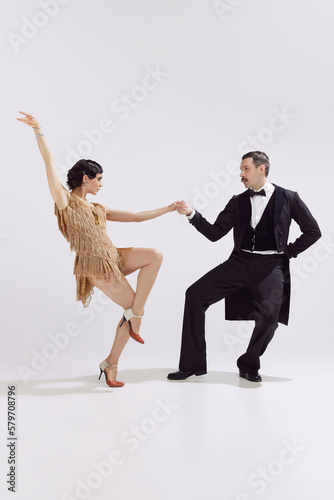 Passion. Elegant couple of dancers in vintage evening dress and suit dancing retro ballroom dance. Love and music, vintage fashion.
