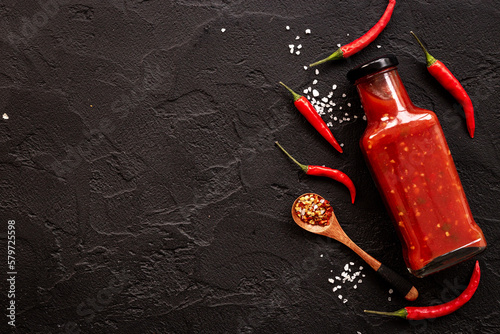 Bottle of spicy sauce tabasco with red hot chili pepper, top view