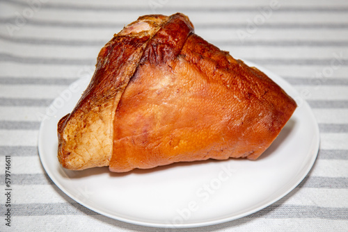 Smoked pork knuckle, traditional German dish, isolated portrait and in selective focus