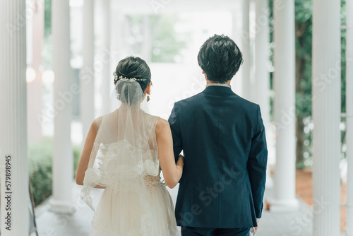 結婚式場を歩く新郎新婦の後ろ姿（入場・結婚式・アジア人） 