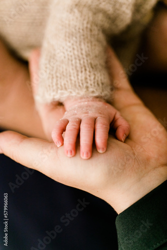 Winzige Babyhand auf Hand der Mutter