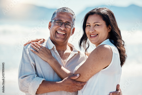 Love, beach and portrait old couple in embrace, smile on face and romance in happy relationship. Romantic retirement vacation, senior woman and mature man hugging on tropical ocean holiday travel.