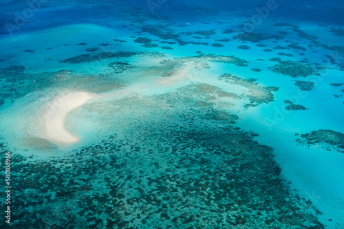 An aerial view of Michaelmas Cay in the Great Barrier Reef: tropical white sand bar, coral reefs, clear turquoise waters — Coral Sea, Cairns; Far North Queensland, Australia