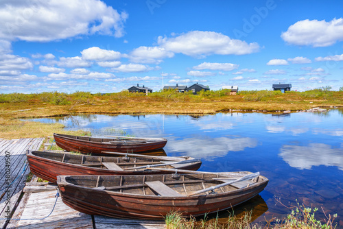 Idyllic landscape view with row boats at a mountain huts jetty