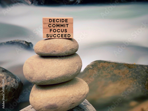 Inspirational and motivational words of decide commit focus succeed on wooden blocks with vintage background.