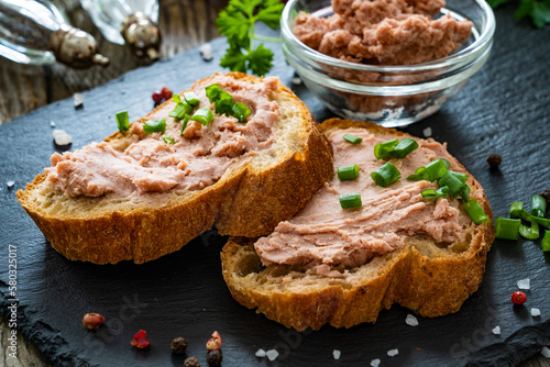 Tasty sandwiches with liverwurst and chive on wooden table 