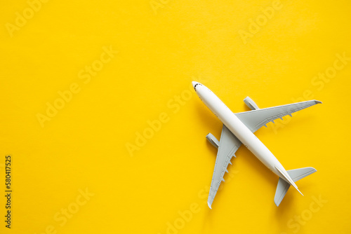 Airplane model on yellow background isolated, flat lay, air ticket, travel and vacation concept, copy space.