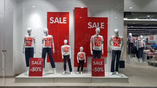 mannequins and the inscription sale on the shop window. 