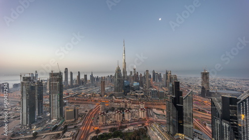 Aerial view of tallest towers in Dubai Downtown skyline and highway night to day timelapse.