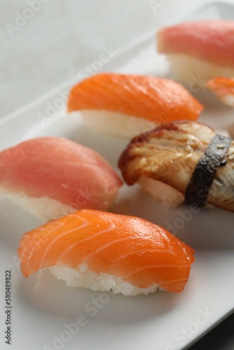 Plate with delicious nigiri sushi on grey table, closeup