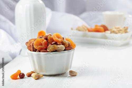 Dried fruits and assorted nuts on a white table.
