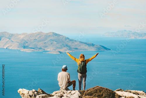 Couple travelers hiking in Greece together outdoor travel lifestyle active summer vacations man and woman on Akramitis mountain top enjoying aerial sea view explore Rhodes island