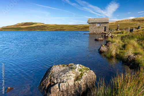 A beautiful old two-storey stone boathouse on the shores of Devoke Water in the Lake District National Park.