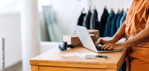 Online store owner using a laptop in her shop