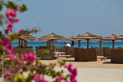 Egypt - beach chairs and umbrellas in traditional style on a beach in soma bay