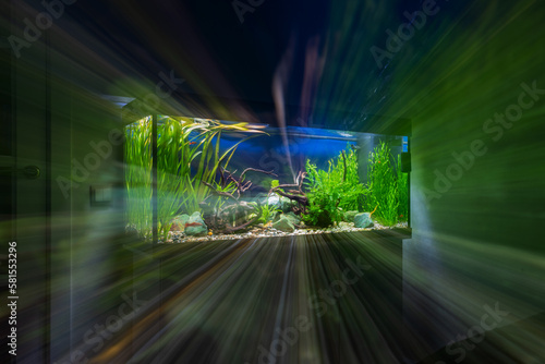 Abstract background with an aquarium in a dark room. Multiple exposure with changing the focal length of the lens when shooting.