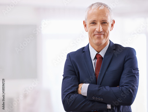 Suiting up for success. a mature businessman with folded arms.