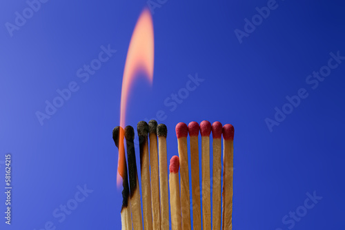 Burning and whole matches on blue background. Stop destruction concept