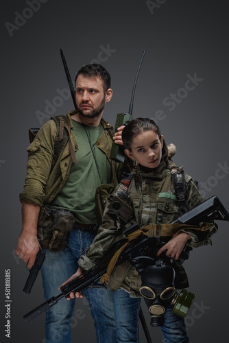 Portrait of man with young girl with rifle and handgun surviving after disaster.